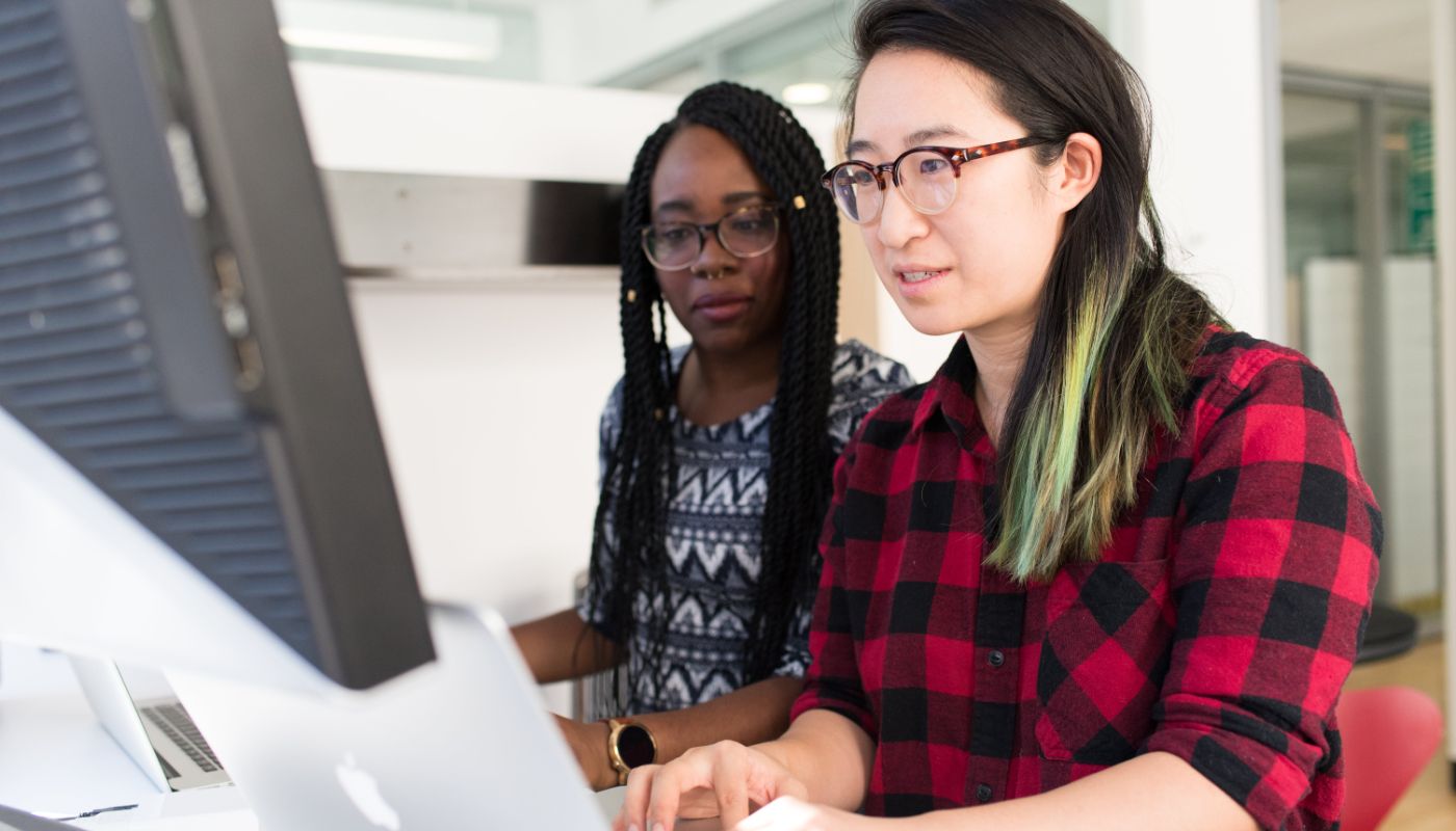 two foreign women using a laptop